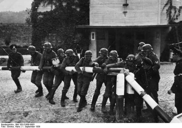 black-and-white photograph by Hans Sönnke showing German soldiers simulating the demolition of a Polish tollgate.