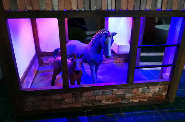 Photo of a miniature horse stable in the making. Inside are two plastic horses.